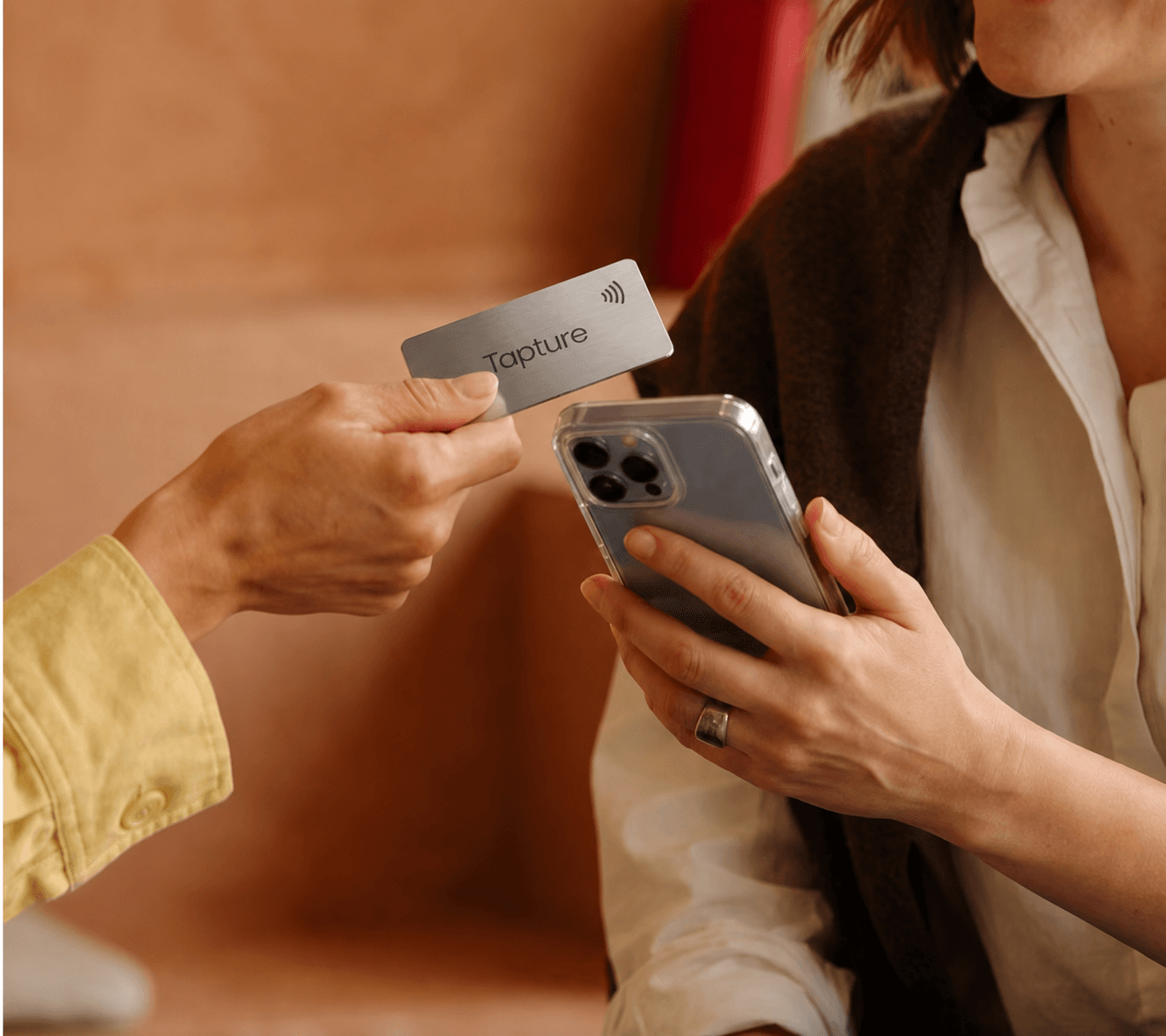 A Tapture NFC business card being tapped on a phone